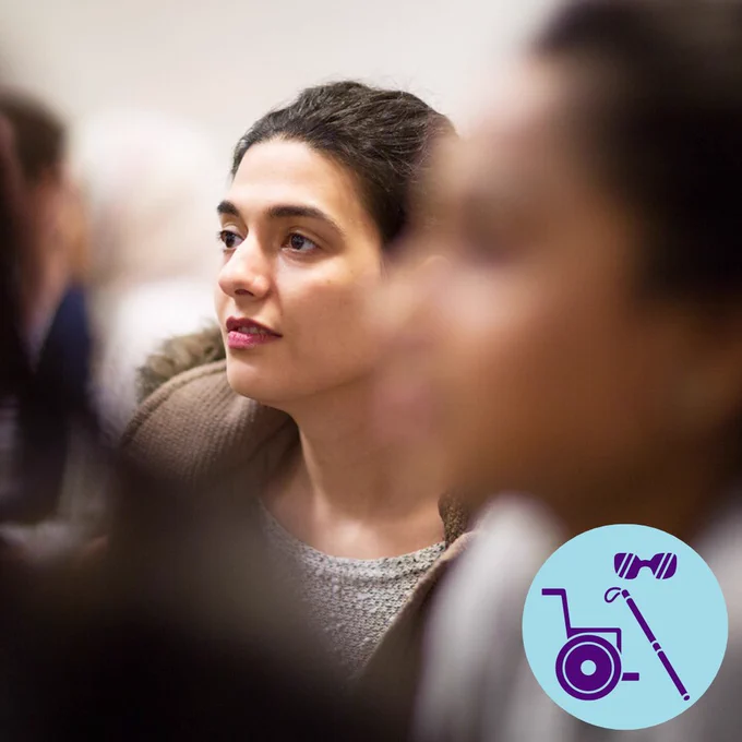 Photo of student in UCL's ear institute. Photo has blue badge with purple disability icons.