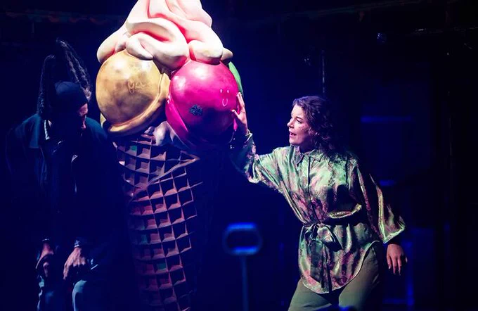 A performer on stage next to a giant ice cream cone