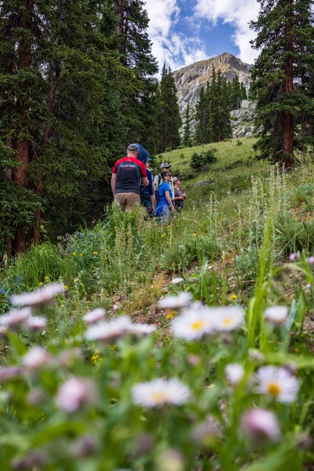 a group of hikers go up the half moon hiking trail with a guide on a wildflower hike