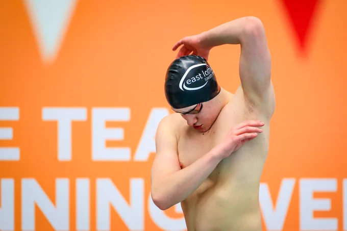 Sam Downie stretches pre-race at the British Para-Swimming Meet 2023.