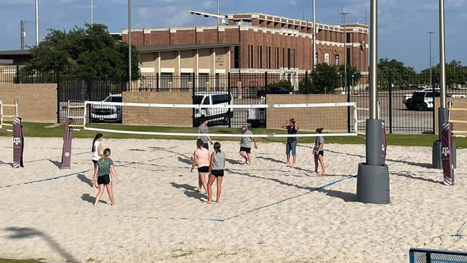 Camp attendees play sand volleyball on the Texas A&M campus. 