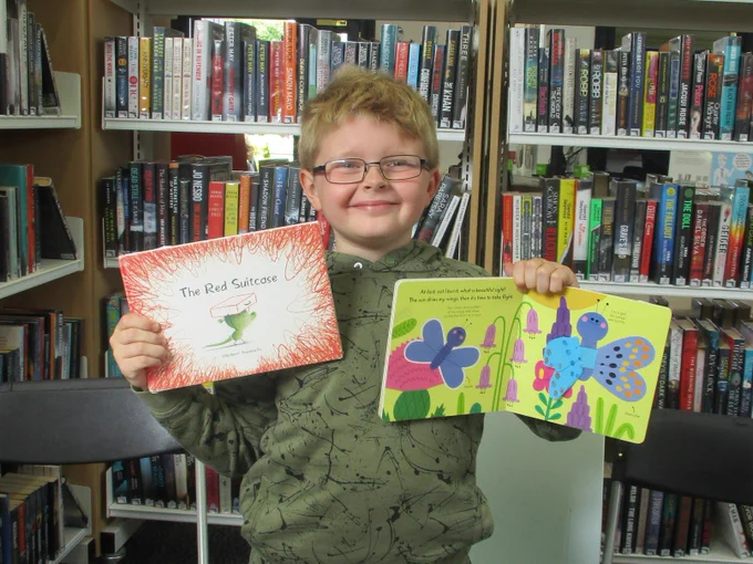 boy holding two books
