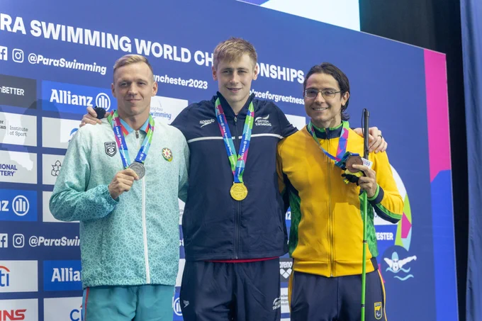 Stephen Clegg (centre) stands on the podium for the S12 Men's 100m Backstroke on day one of the Manchester 2023 Allianz Para Swimming World Championships.