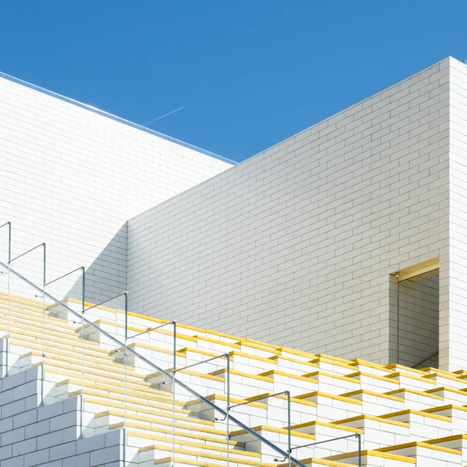 Detail taken on the public roof space of the LEGO House, Billund, Denmark, showing a doorway, staircase and yellow padded outdoor seating.
