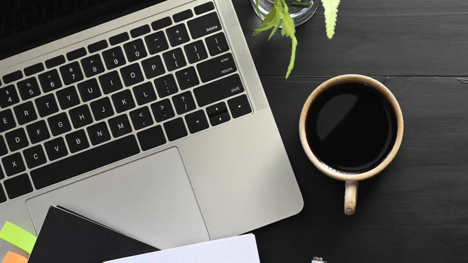 Office Desk Table with Laptop, coffe, plant and notebook