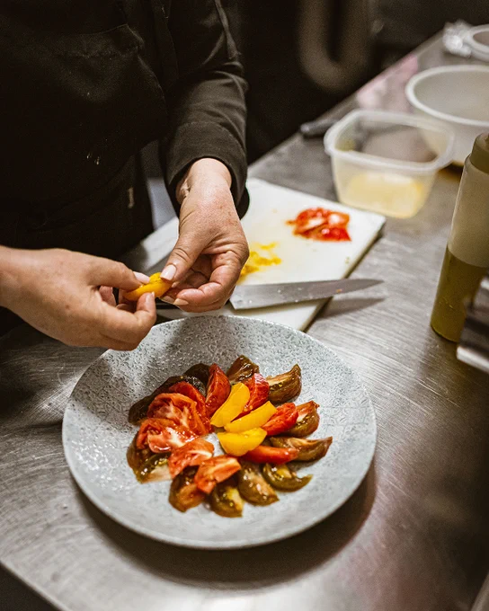 Foto del trabajo en cocina cortando y pelando los tomates.
