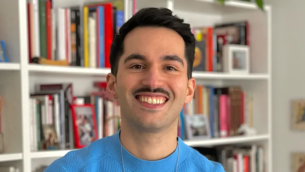 headshot photo of Daniel Valtuena in front of bookshelves