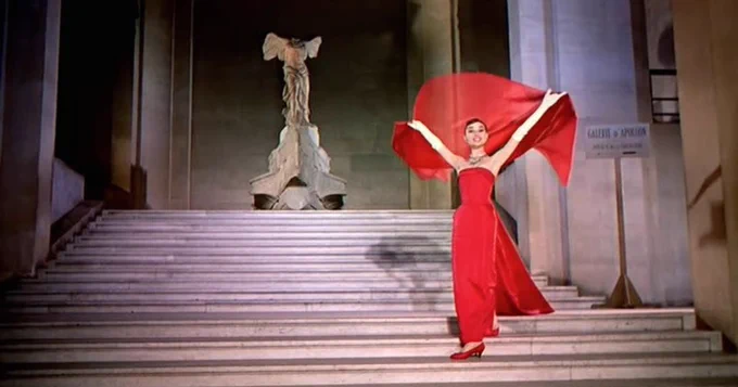 Artwork for Funny Face. A woman in a red dress performing on a set of stone stairs.