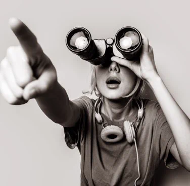 black & white image of a girl using binoculars
