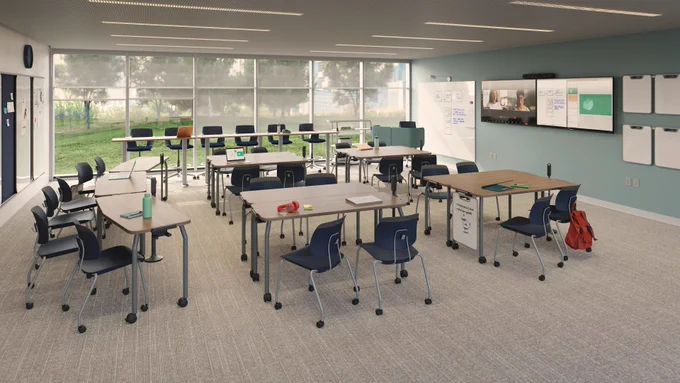 A modern classroom with multiple sets of Steelcase Learning Tenor rolling desk chairs and Agree rolling tables with attached whiteboards.