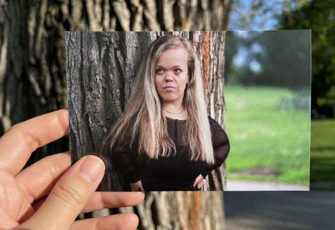 Alexia Vassos as Richard. A picture of a photograph held up delicately by a hand. The two locations are lined up to create a portal effect.