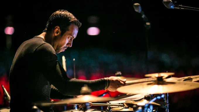 Antonio Sanchez performing on-stage surrounded by cymbals