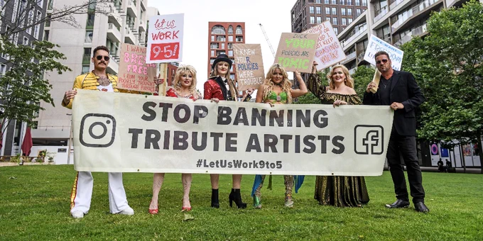 A group of celebrity tribute artists holding up a sign that says Stop Banning Tribute Artists outside the Meta HQ in London