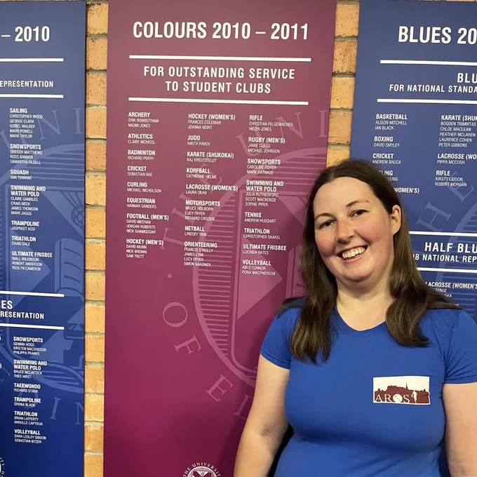 image of Blues and colours recipient in front of their award board at the Pleasance Gym