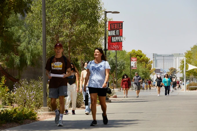 Students walking on a sidewalk on a sunny day