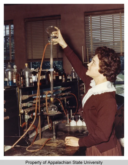 This image shows a student working in a laboratory classroom in the newly completed Rankin Science Building at Appalachian State Teachers College (1929-1967) in the early 1960s. She can be seen pouring a liquid from a beaker into a tube. The Rankin Science Building included classrooms and laboratories for the Departments of Biology, Geology, Chemistry, and Physics. It was completed in 1963 and dedicated to Dean Emeritus James Daniel Rankin.