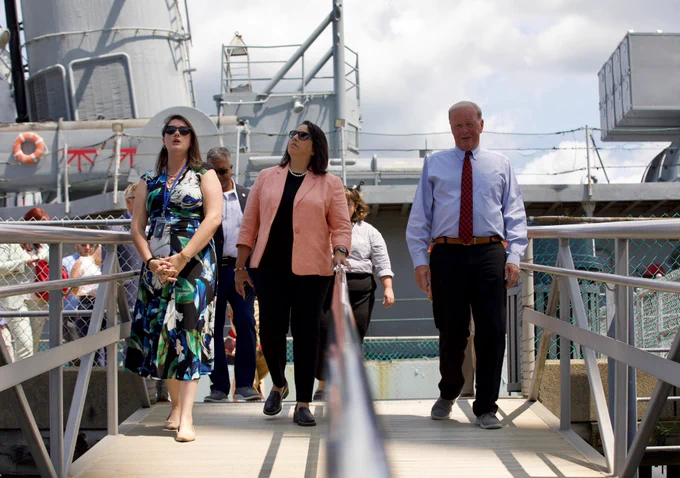 LG and group of people disembarking battleships.
