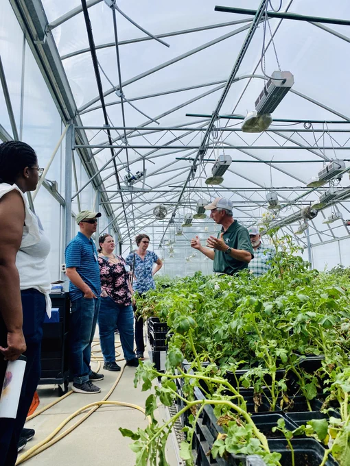Nourish the Future takes teachers into the facilities where science is happening. Here, science teachers tour a greenhouse researching potato genetics.  