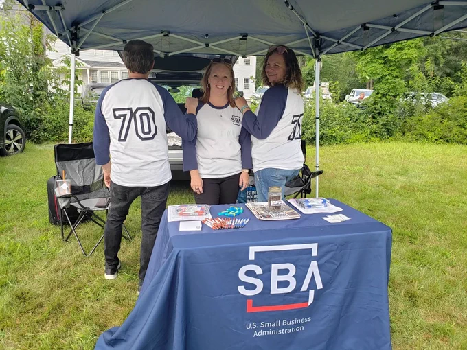 Staff with 70th anniversary shirts at booth