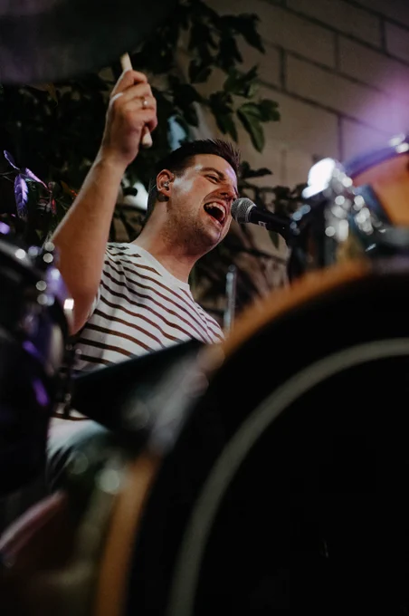 Toni (bateria) toca i canta al micròfon amb ganes.