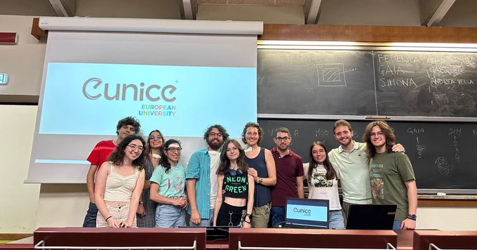 Some of University of Catania's students who have joined the local group, in the background a blackboard and a screen with Eunice logo