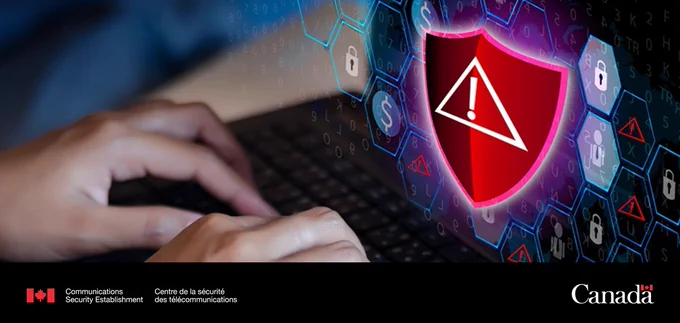 Hands on a laptop keyboard. There's an alert sign on the screen.