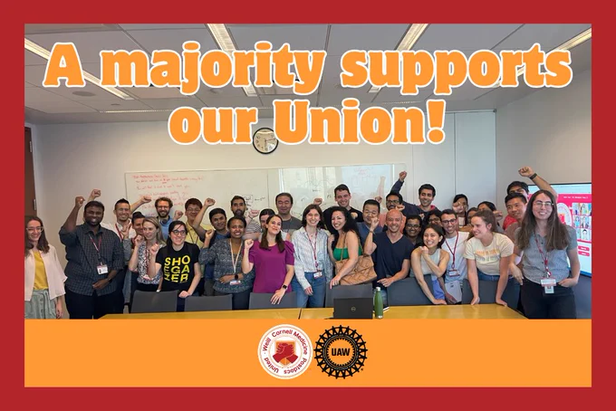 Photo of a large group of postdocs gathered together. Many are raising their fists. Text reads, "A majority supports our Union!"