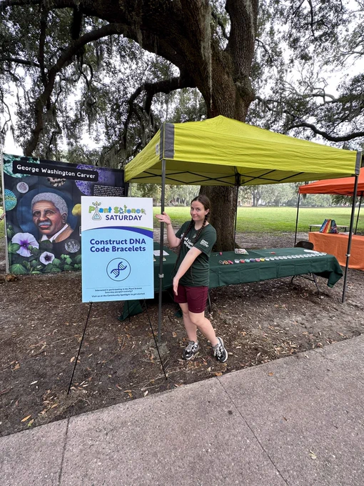 A volunteer posed for a photo next to the Construct DNA Code sign!