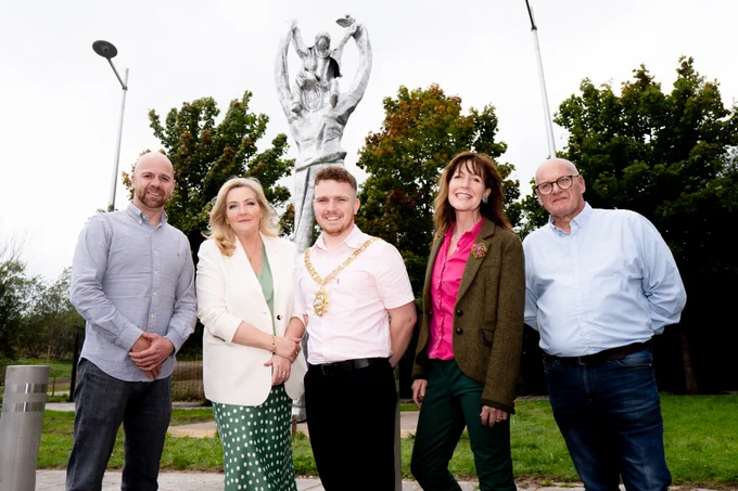 Shared City Partnership Chair Councillor Joe Duffy, Gina McIntyre from SEUPB, Belfast Lord Mayor Councillor Ryan Murphy, artist Sara Cunningham-Bell and Shared City Partnership Deputy Chair Councillor Ian McLaughlin with Carry Each Other sculpture in background