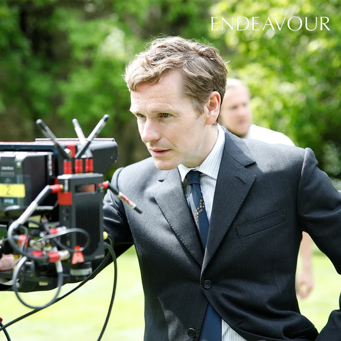 Actor Shaun Evans, who plays Endeavour Morse, looking into a camera monitor whilst on set in an outdoor location.