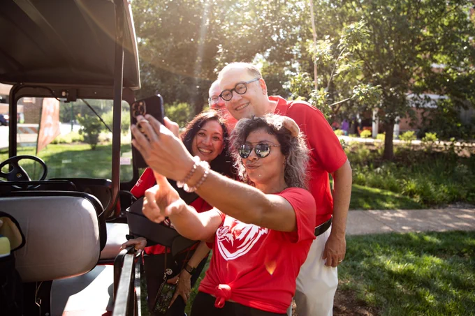Chancellor Martin, Dr. G, and Rob Wild take a selfie with a student during move-in weekend.