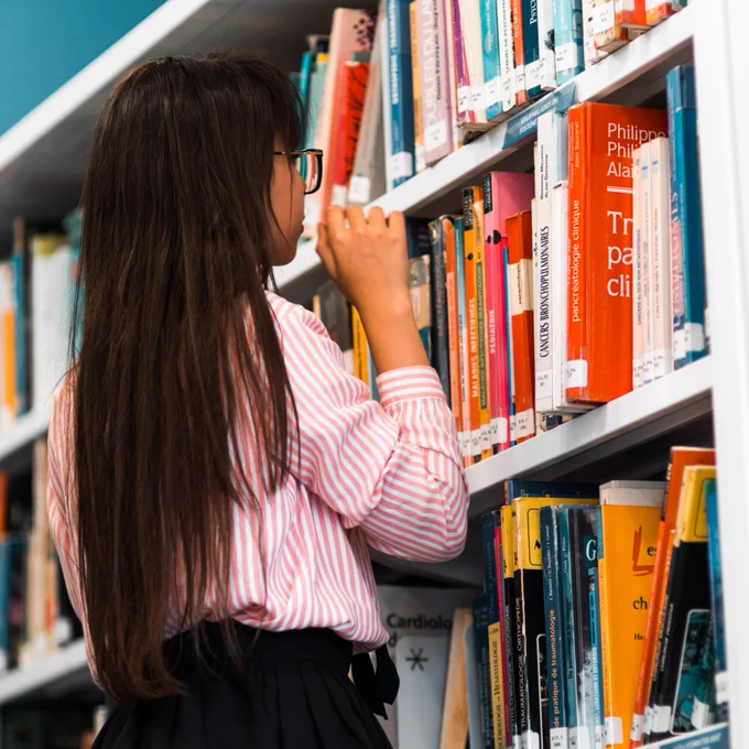 Girl browsing library shelves.