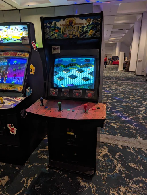 A Marble Madness 2: Marble Man arcade game. Cabinet is the same as Rampart. This game has joysticks and a wood grain pattern control panel. 
