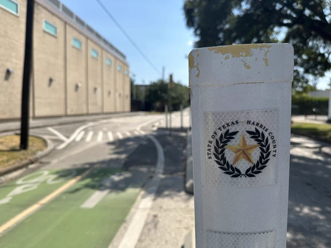Bike lane with a big Harris county logo on the flex post stick.