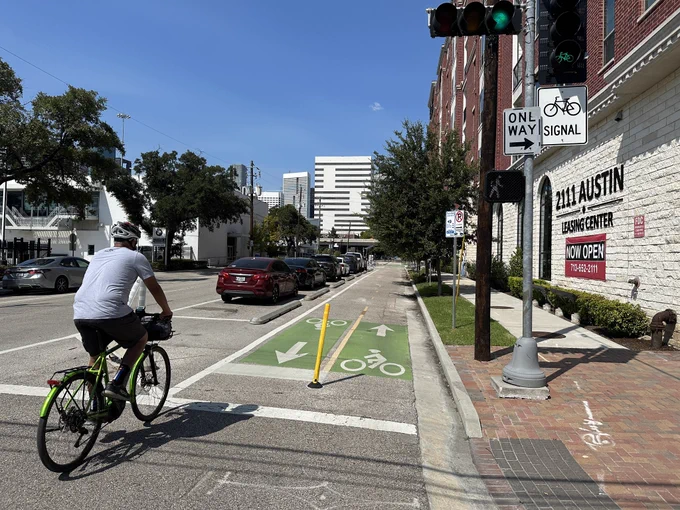 Two way bike lane on a one way street with parked cars protecting the bike lane