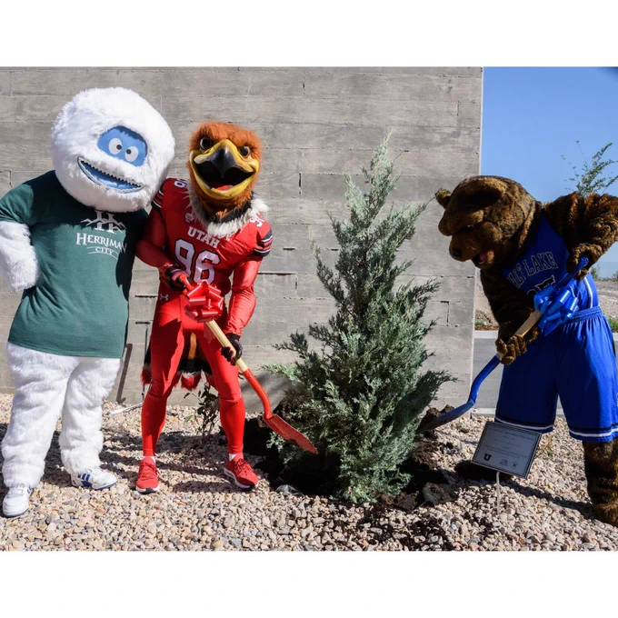 Brutus the Bruin plants a tree with Swoop the Eagle and the Herriman Yeti at the new Herriman Campus.
