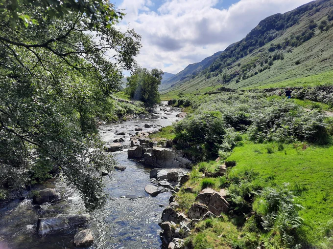A beck running down a lush green valley 