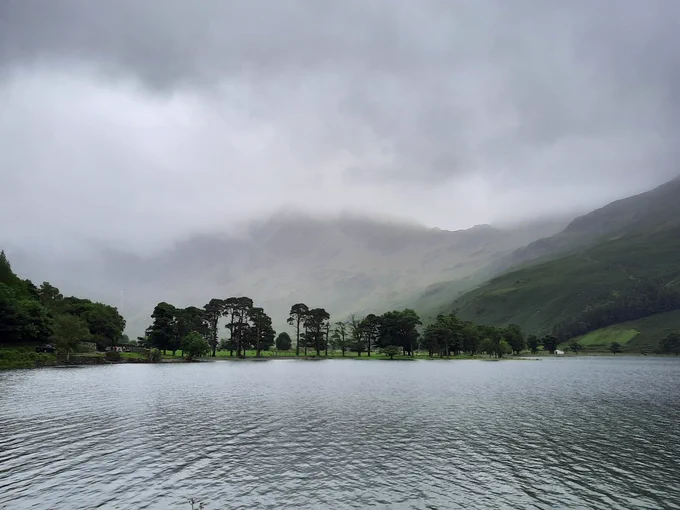 Buttermere with low cloud and a row of trees in the distance 