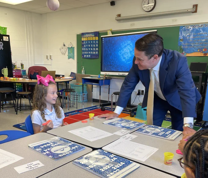 Superintendent Dr. Marty Pollio talks to a student in a classroom.