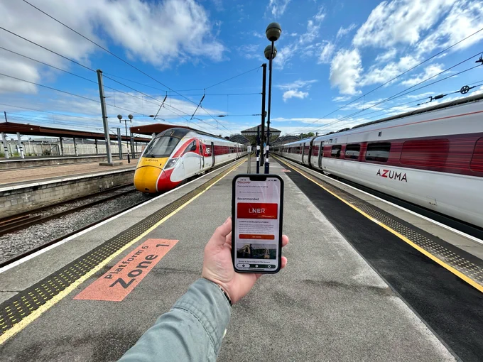 POV of person holding a photo with Window Seater app open on York station platform with LNER Azuma at either side. 