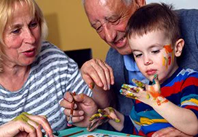 Toddler painting with grandparents