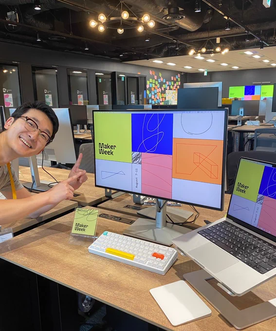 Man pointing to computer screen with maker week branding