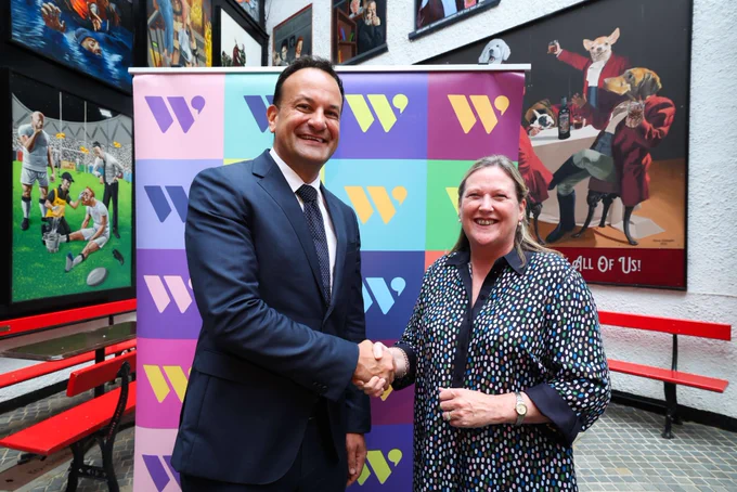 Leo Varadkar Taoiseach of Ireland and CEO WiB Group Roseann Kelly MBE pictured i front of a colour w wall in front of Murials at the Dark Horse Belfast. Both smiling and shaking hands.