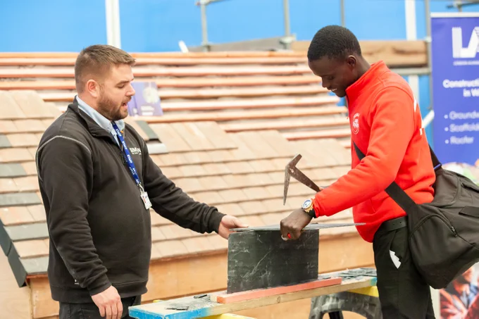 Attendee at construction job fest hammering a slate.