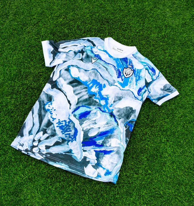 An incredible design with a swirling ice and water pattern, shades of light and dark blue contrasted with whites and greys. The shirt is made by macron.