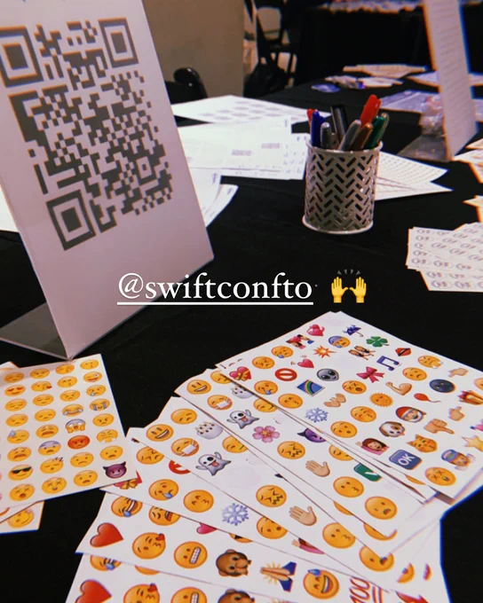 Table with stickers and a text that mentions Swift Conference TO social media account and a raised hand emoji 