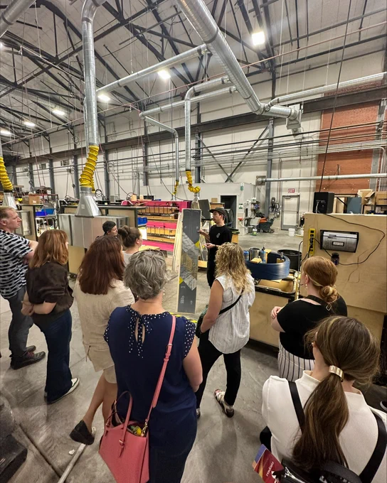 A group of teachers are being shown a pair of skis that have been made with biobased materials. 