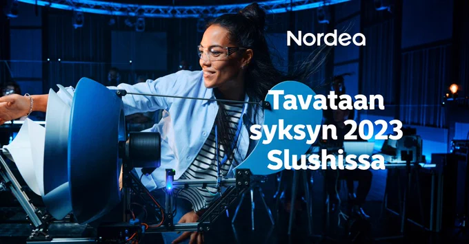 Suojalaseihin sonnustautunut, hymyilevä nuori aikuinen seisoo pöydällä olevan keksintönsä takana kädet sivuille levitettyinä. Teksti: "Tavataan syksyn 2023 Slushissa".