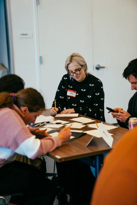 Photo of a woman drawing sketches in a group at a design challenge workshop