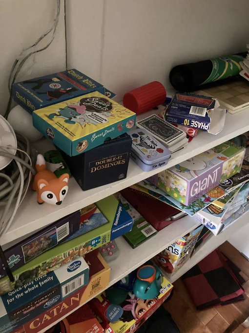 A shot of many board games on some shelves with Sweet Deals & Tin Spin included